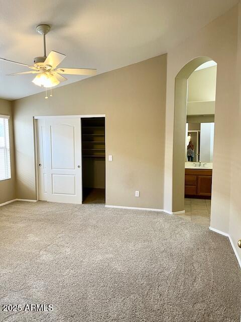 6376 W Adobe Dr, Glendale, AZ 85308 - unfurnished bedroom with light carpet, arched walkways, baseboards, a closet, and a sink