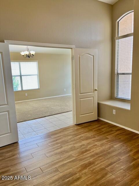 6376 W Adobe Dr, Glendale, AZ 85308 - unfurnished room featuring wood finished floors, a chandelier, and baseboards