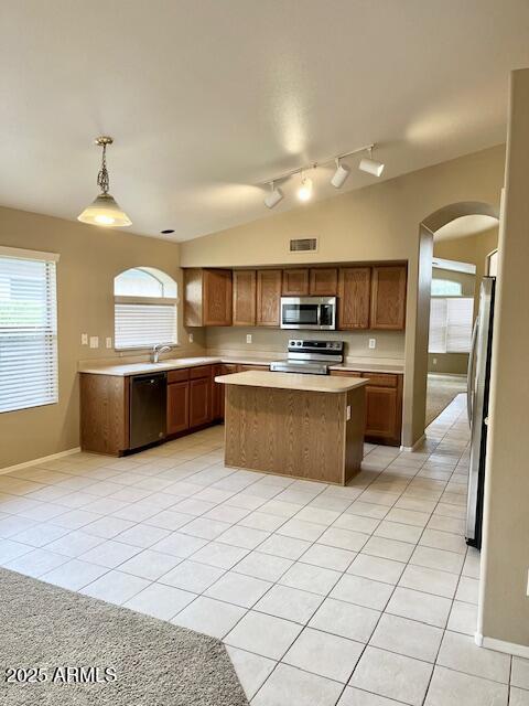 6376 W Adobe Dr, Glendale, AZ 85308 - kitchen with appliances with stainless steel finishes, arched walkways, light countertops, light tile patterned flooring, and rail lighting