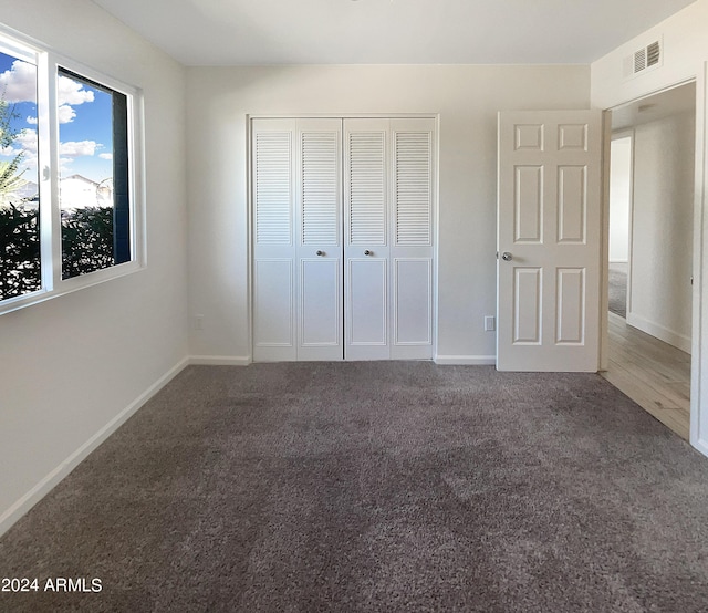 unfurnished bedroom featuring carpet floors and a closet