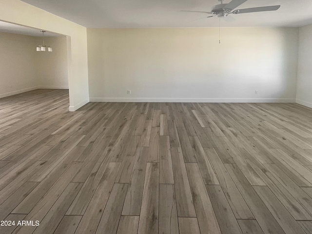 empty room with ceiling fan and light wood-type flooring