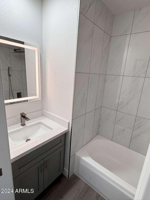 bathroom with vanity, hardwood / wood-style flooring, and tiled shower / bath combo