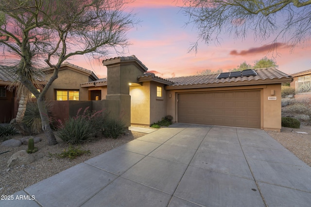 11400 E Helm Dr, Scottsdale, AZ 85255 - mediterranean / spanish house with driveway, stucco siding, roof mounted solar panels, an attached garage, and a tiled roof