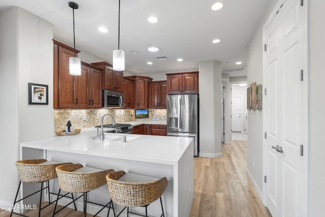11400 E Helm Dr, Scottsdale, AZ 85255 - kitchen featuring appliances with stainless steel finishes, a peninsula, a sink, light countertops, and tasteful backsplash