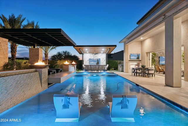 pool at dusk featuring a patio area