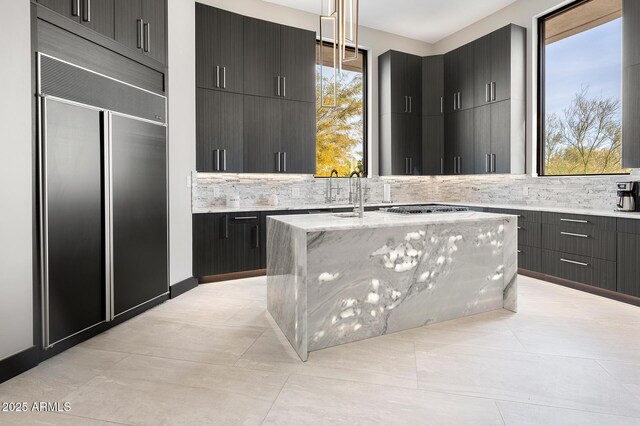 3282 E Palo Verde Dr, Paradise Valley, AZ 85253 - kitchen featuring decorative light fixtures, paneled built in fridge, an island with sink, sink, and stainless steel gas cooktop