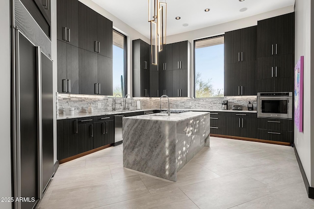 3282 E Palo Verde Dr, Paradise Valley, AZ 85253 - kitchen with stainless steel appliances, tasteful backsplash, sink, hanging light fixtures, and a kitchen island with sink
