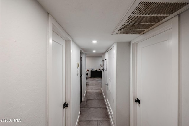 corridor featuring baseboards, visible vents, and recessed lighting