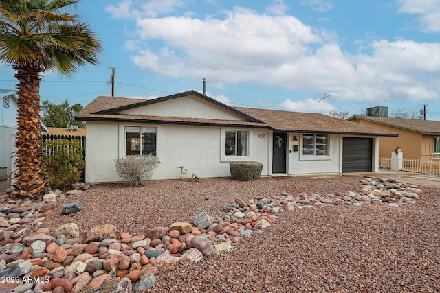 ranch-style home featuring central air condition unit, stucco siding, concrete driveway, fence, and a garage