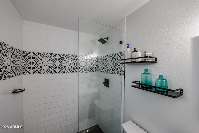 bathroom with toilet, walk in shower, and a textured wall