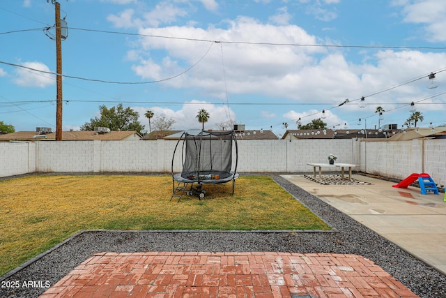 view of yard featuring a patio area, a fenced backyard, and a trampoline