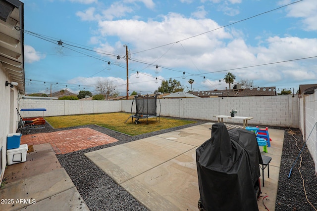 view of yard with a trampoline, a patio area, and a fenced backyard