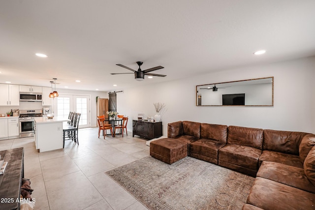 living area with light tile patterned floors, a ceiling fan, and recessed lighting