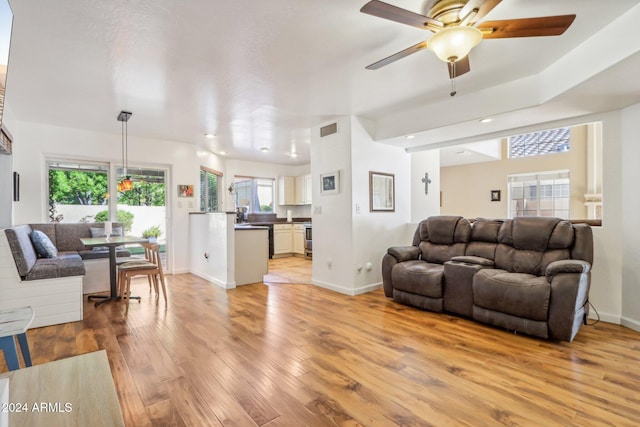 living room featuring light hardwood / wood-style flooring and ceiling fan