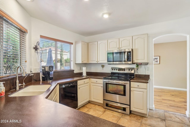 kitchen with sink, light tile patterned floors, and stainless steel appliances