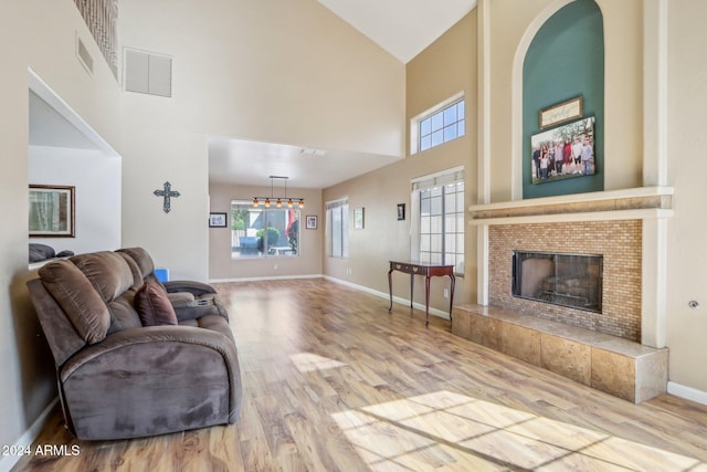 living room with a fireplace, high vaulted ceiling, and hardwood / wood-style floors