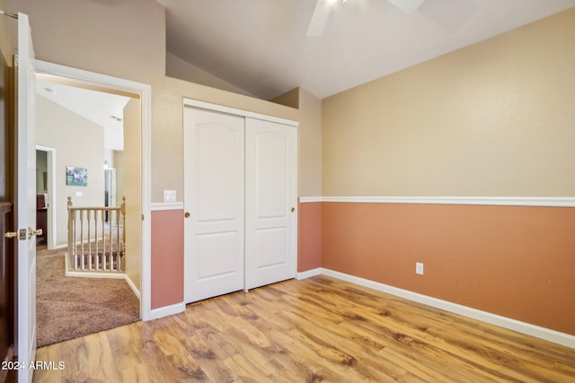 unfurnished bedroom featuring light hardwood / wood-style floors, a closet, lofted ceiling, and ceiling fan