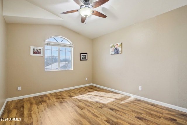 spare room with wood-type flooring, vaulted ceiling, and ceiling fan