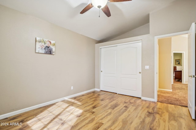 unfurnished bedroom with a closet, vaulted ceiling, ceiling fan, and light hardwood / wood-style flooring