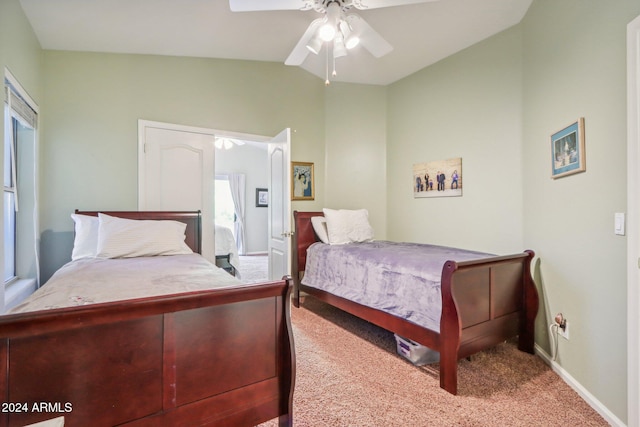 bedroom with ceiling fan, lofted ceiling, and light carpet