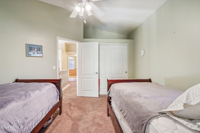 carpeted bedroom with ceiling fan, a closet, and vaulted ceiling