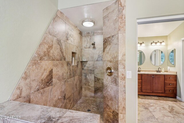 bathroom with tiled shower and vanity