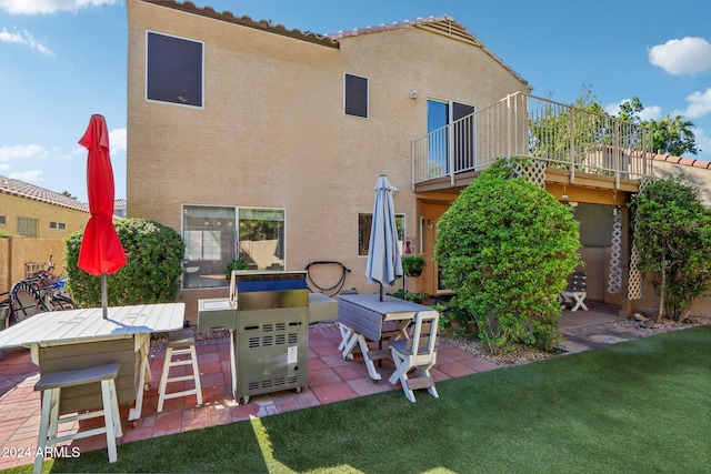 back of house with a lawn and a patio