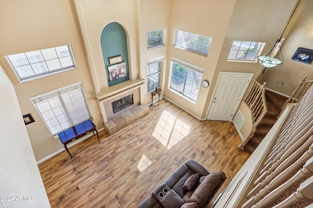 living room with a fireplace, a high ceiling, and hardwood / wood-style flooring