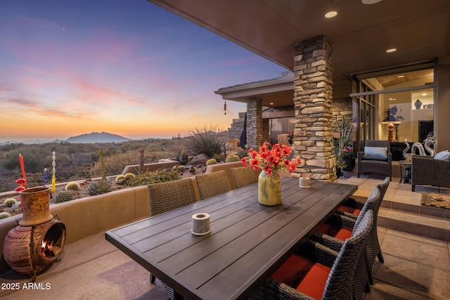 patio terrace at dusk with outdoor lounge area and a mountain view