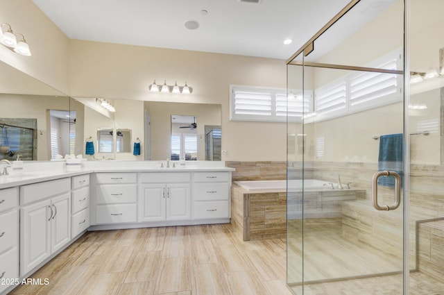 bathroom with vanity, ceiling fan, and plus walk in shower