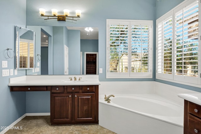 full bathroom featuring a garden tub, vanity, and baseboards