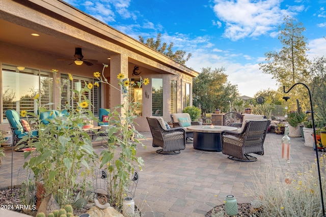 view of patio featuring ceiling fan and an outdoor living space with a fire pit