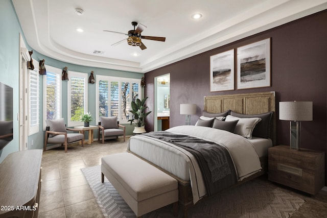 bedroom with tile patterned flooring, visible vents, a tray ceiling, and recessed lighting