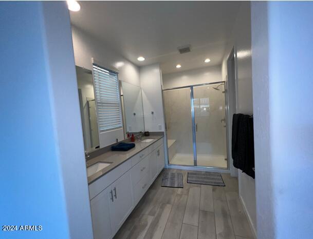 bathroom with vanity, hardwood / wood-style floors, and walk in shower