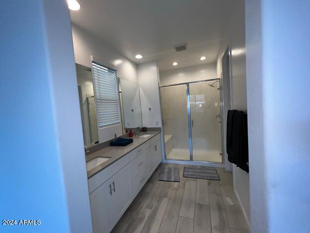 bathroom featuring a shower with door, vanity, and hardwood / wood-style floors