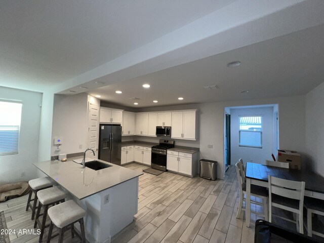 kitchen featuring sink, kitchen peninsula, stainless steel appliances, and plenty of natural light