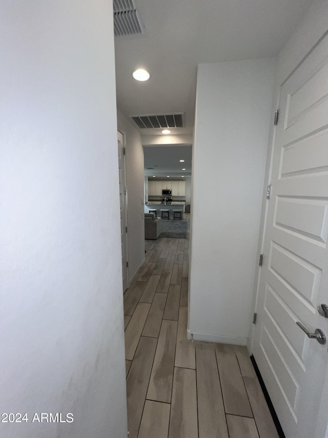 corridor with light hardwood / wood-style flooring