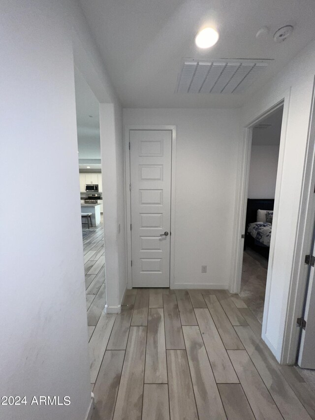 hallway with light hardwood / wood-style floors