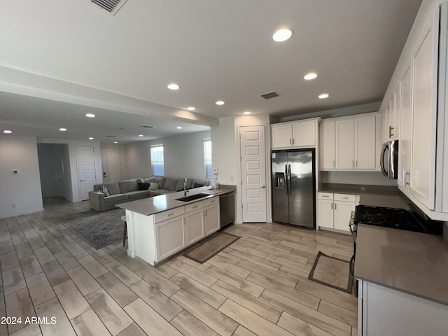 kitchen featuring appliances with stainless steel finishes, light wood-type flooring, and white cabinets