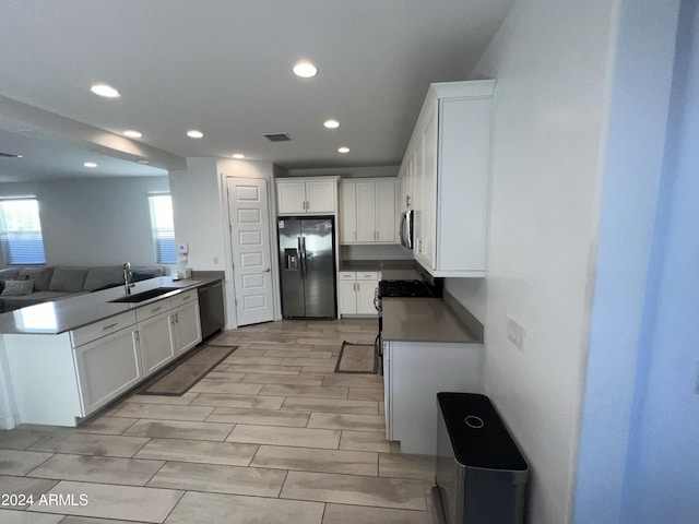 kitchen featuring light hardwood / wood-style floors, stainless steel appliances, sink, and white cabinets