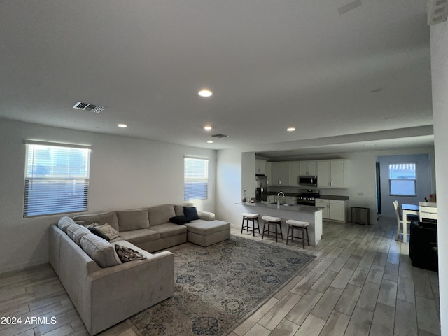 living room with sink and light wood-type flooring