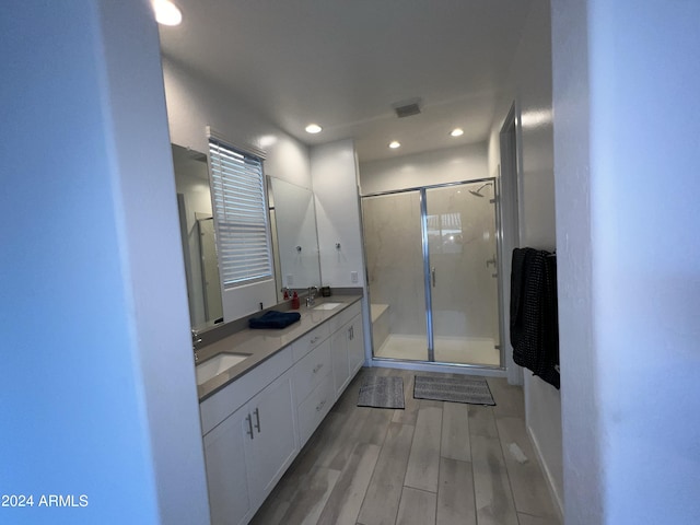 bathroom featuring vanity, hardwood / wood-style flooring, and a shower with shower door