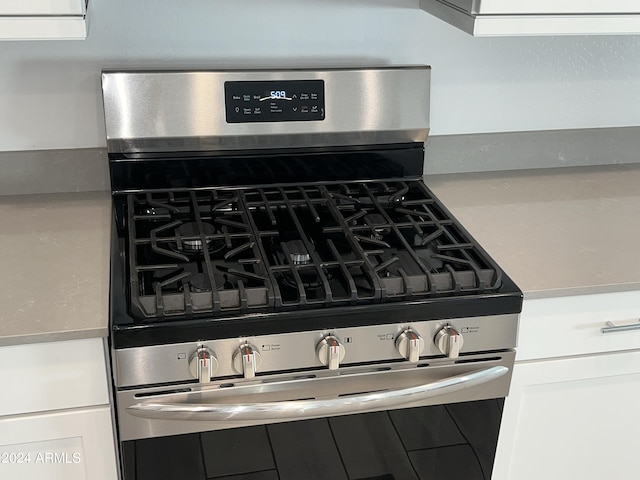 interior details with white cabinetry and stainless steel gas range