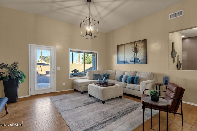 living room featuring a chandelier and light wood-type flooring