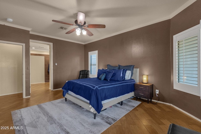 bedroom featuring hardwood / wood-style floors, ceiling fan, and crown molding