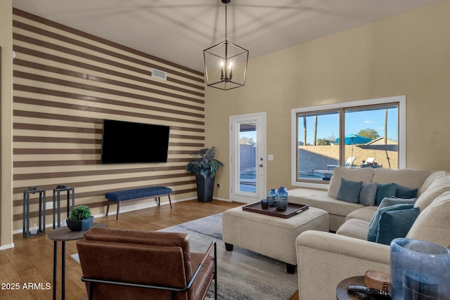 living room with a high ceiling, hardwood / wood-style flooring, and a notable chandelier