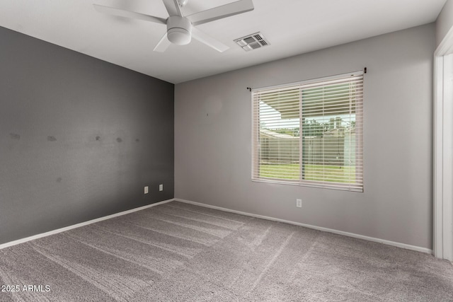 carpeted spare room featuring baseboards, visible vents, and a ceiling fan