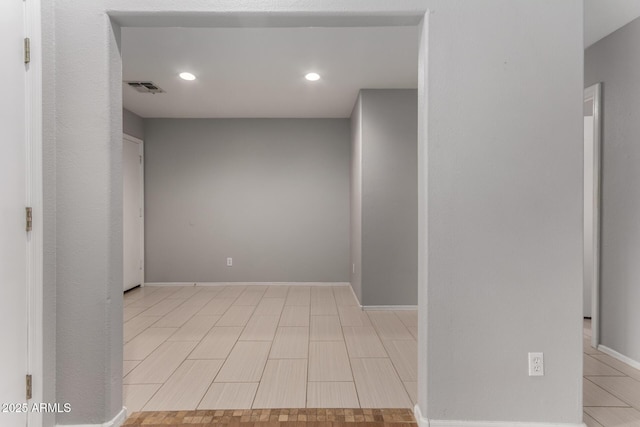 unfurnished room featuring baseboards, visible vents, and recessed lighting