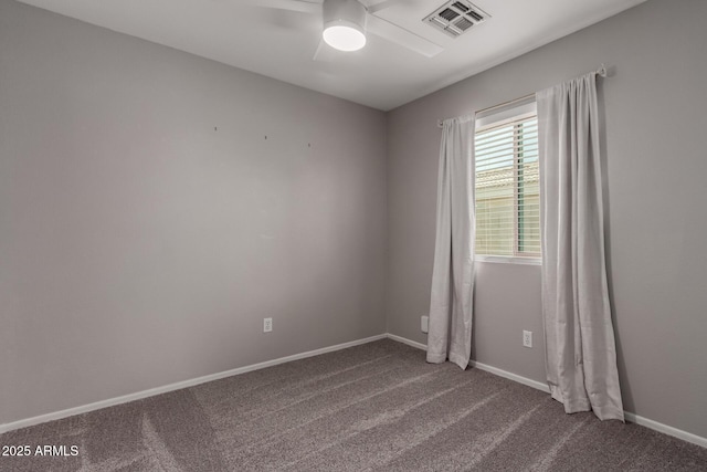 unfurnished room featuring visible vents, dark carpet, baseboards, and ceiling fan