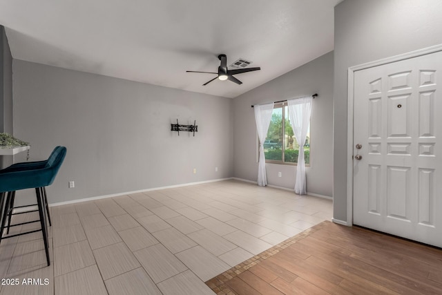 foyer entrance featuring visible vents, vaulted ceiling, ceiling fan, wood finished floors, and baseboards